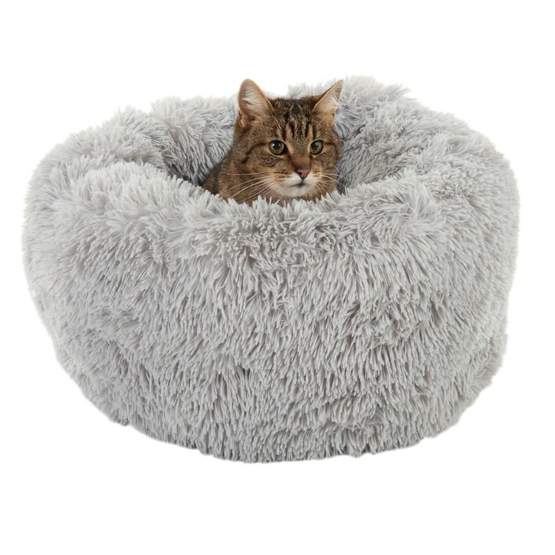 Grey, round cat bed made of fluffy material with a cat inside.