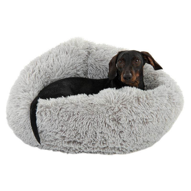 Dog lying in a grey, fluffy pet bed. Product shows comfort and design of the bed.