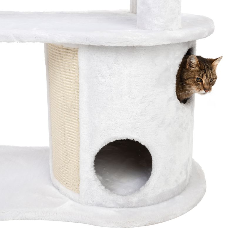 Cat tree with white plush cover, cave with two openings and sisal scratching surface. Cat looking out from one of the openings.