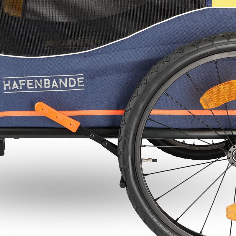 Hafenbande bicycle trailer with blue fabric, orange accents and reflective elements on the wheel.