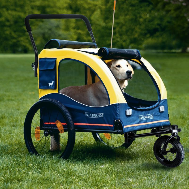 Yellow and blue dog trailer with 'Hafenbande' inscription, three wheels, mesh window and handle. Suitable for transporting pets.