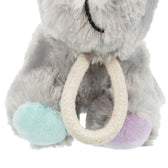 Grey plush toy with a mint green and purple paw and a white rope ring as a handle.