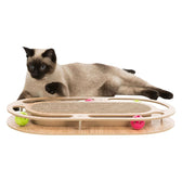 Wooden cat toy with scratching surface and colourful balls in tracks. Siamese cat lying next to it.