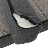 Close-up of a grey dog bed with removable cover and zip, showing inner padding.
