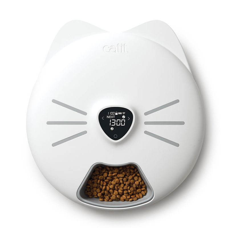 Catit automatic feeder with digital display, shows next feeding time at 13:00. Lower section filled with dry food.