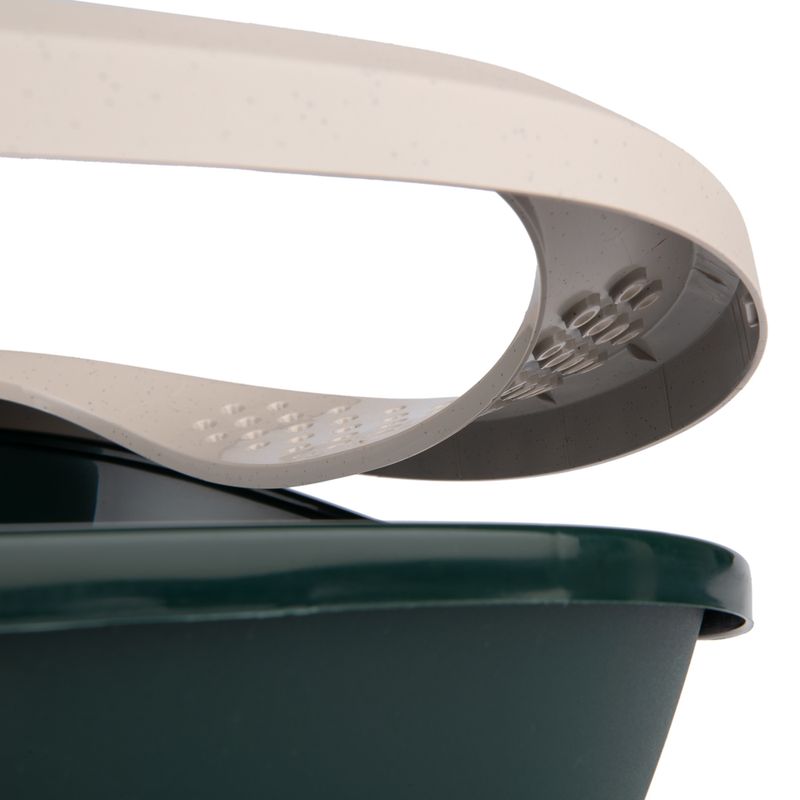 Close-up view of a beige plastic cover with textured surfaces on a dark green container.