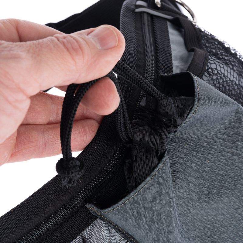 Close-up of a hand pulling a black cord on grey mesh fabric. Detail view of a fastening mechanism.