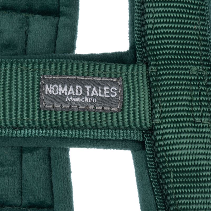 Nomad Tales München. Close-up of green fabric material with brand label.