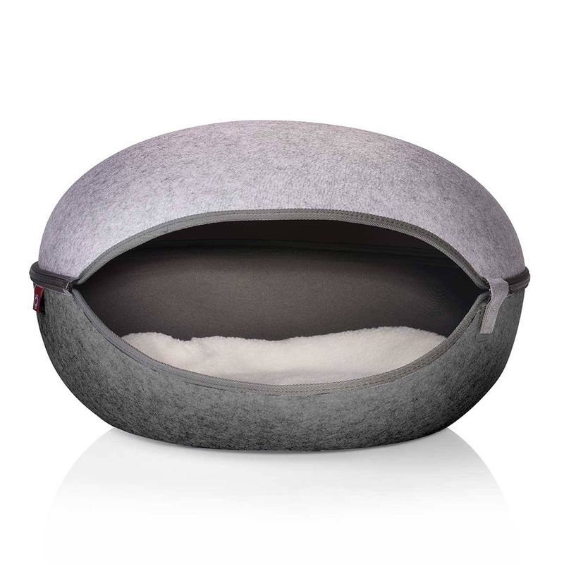Grey, oval pet bed with soft white inner padding and zip opening.