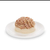 Close-up of served wet food with shredded meat on a white plate.