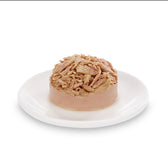 Close-up of served wet food with shredded meat on a white plate.