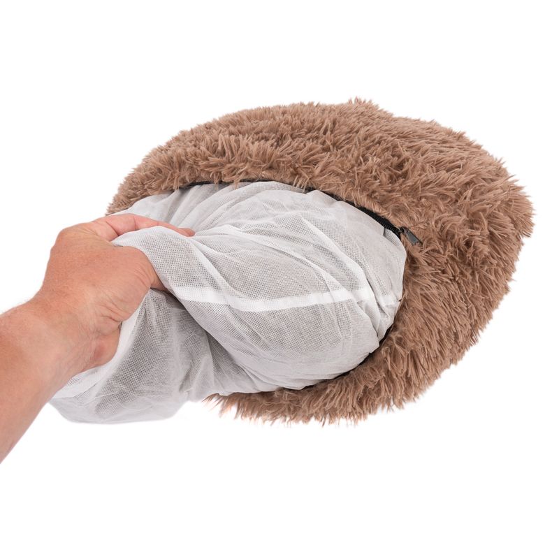 Hand showing removable inner cushion with mesh cover from a brown, fluffy pet bed.