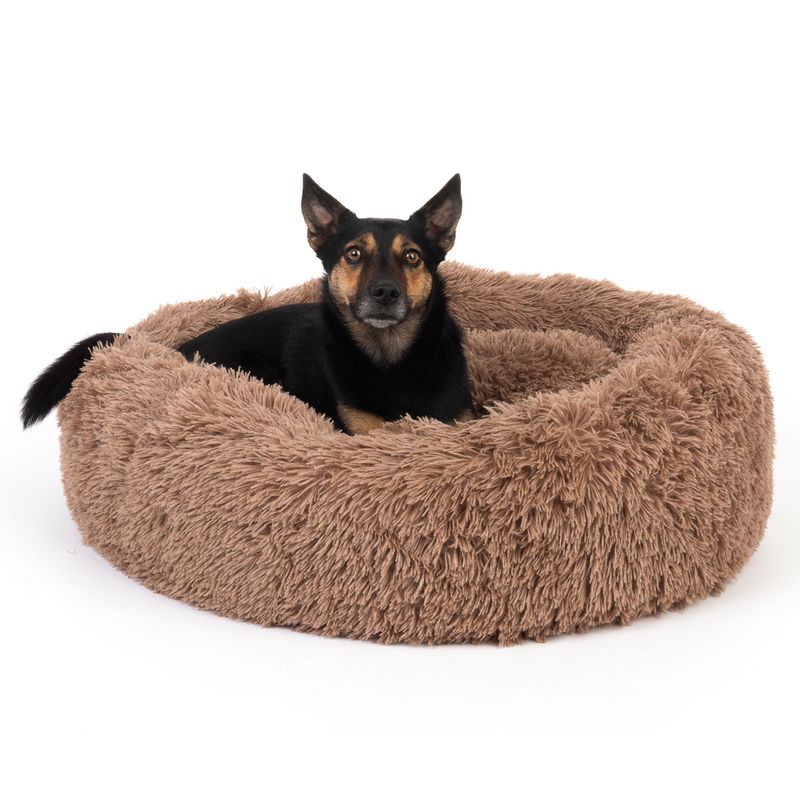Round, fluffy dog bed in brown with raised edge for comfort.