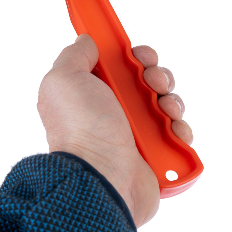 Hand holding orange tool with ergonomic handle and hole at the end, suitable for a secure grip.