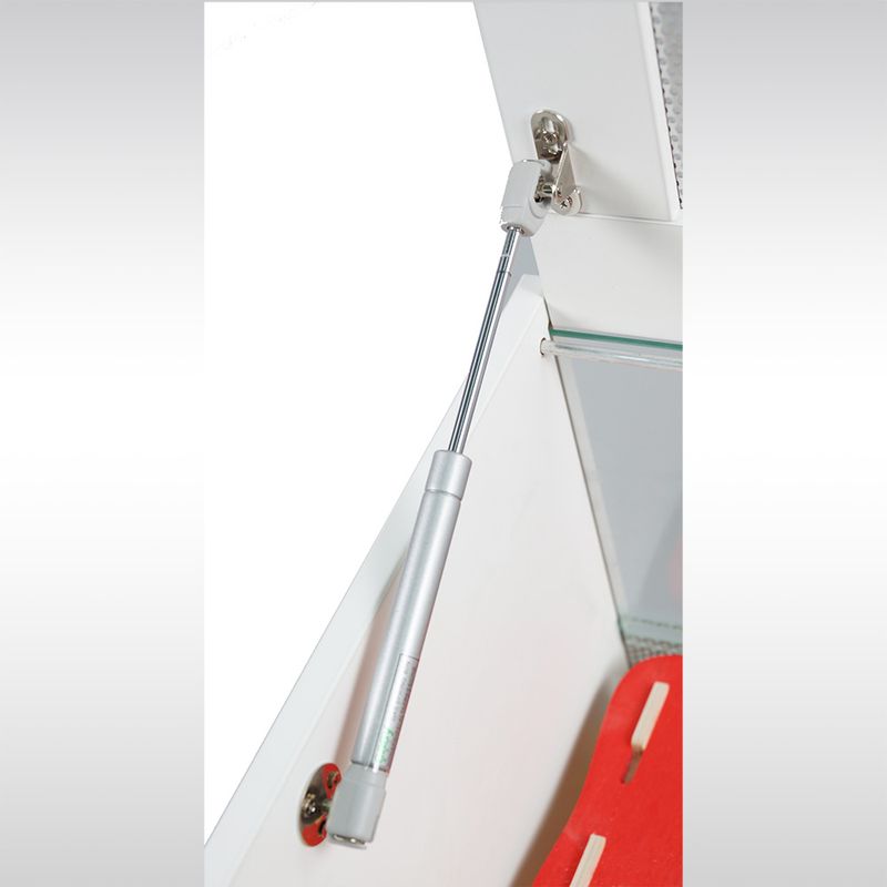 Gas pressure spring made of metal for safe opening and stabilisation of flaps or doors, mounted on white furniture.