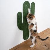 Cat scratching board in cactus shape, wall-mounted. Cat scratches with front paws on green sisal material.