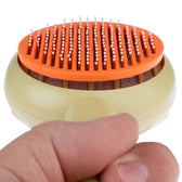 Hand holding a beige-orange brush with fine metal bristles and white tips, suitable for coat care.