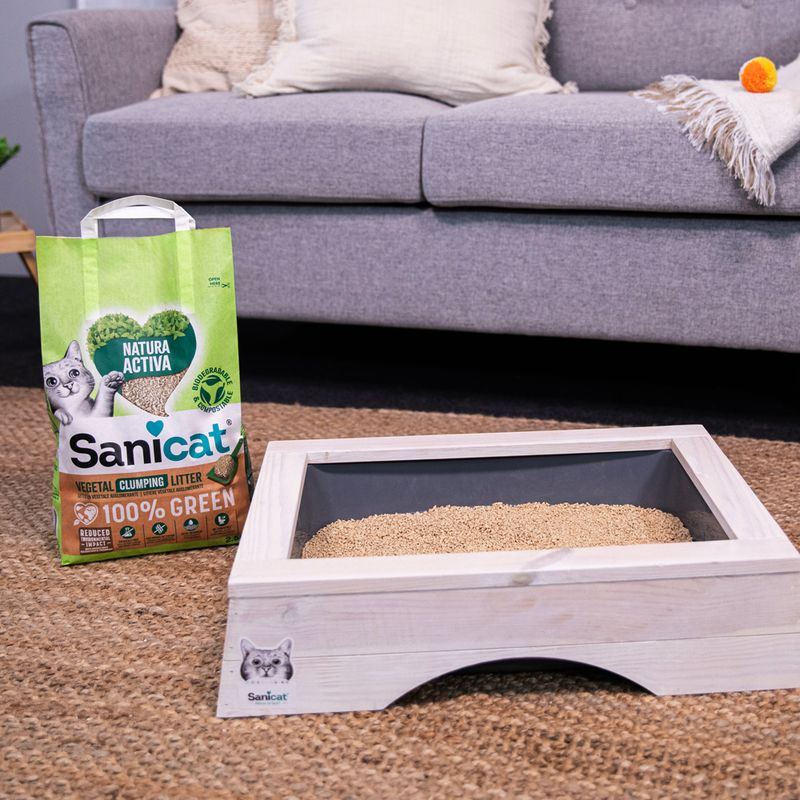 Sanicat Natura Active cat litter, plant-based clumping, 100% biodegradable. Packaging next to a filled wooden litter tray.