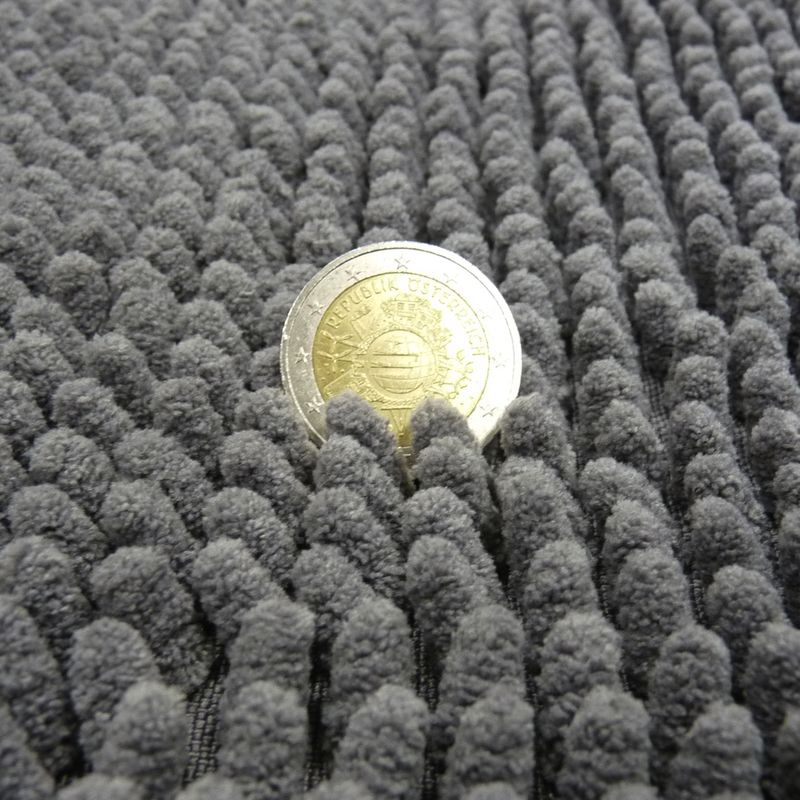 Grey, textured surface with a coin for size comparison. Shows a close-up of the material.