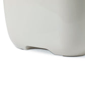 Close-up of a white plastic container with rounded corners and a recess at the bottom.