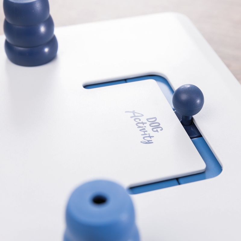 White and blue intelligence toy with 'Dog Activity' inscription, sliding compartment and movable elements.