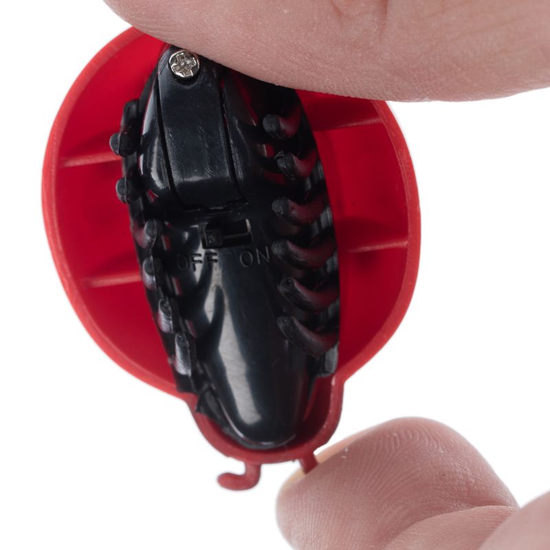 Close-up of a red toy with a black switch labelled 'ON' and 'OFF'.