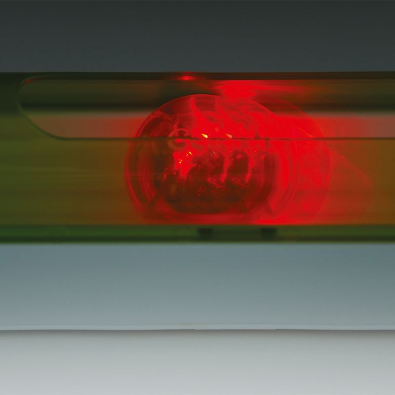Red LED light in a transparent housing, possibly part of a toy or accessory.