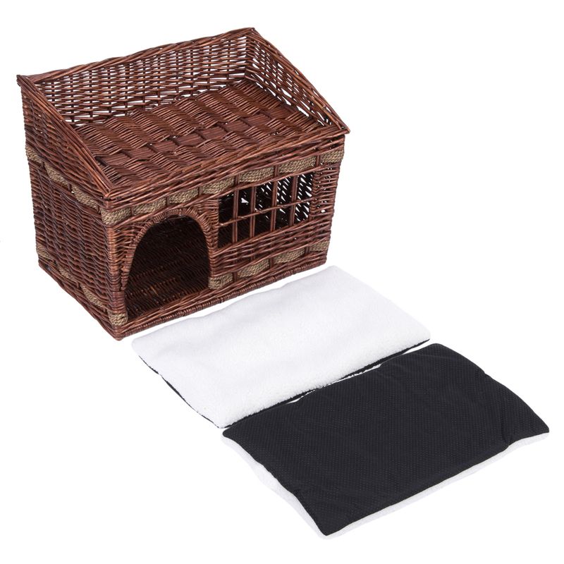 Braided brown basket with roof and entrance, two removable cushions in white and black visible.