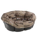 Oval-shaped cushioned pet bed with brown fabric featuring city names such as Paris, London, Tokyo, New York, Hong-Kong and Sydney printed in various fonts.