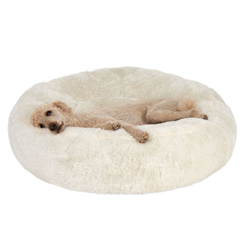 Animal lying on a large, round, fluffy cream-coloured bed, demonstrating the use and size of the product.