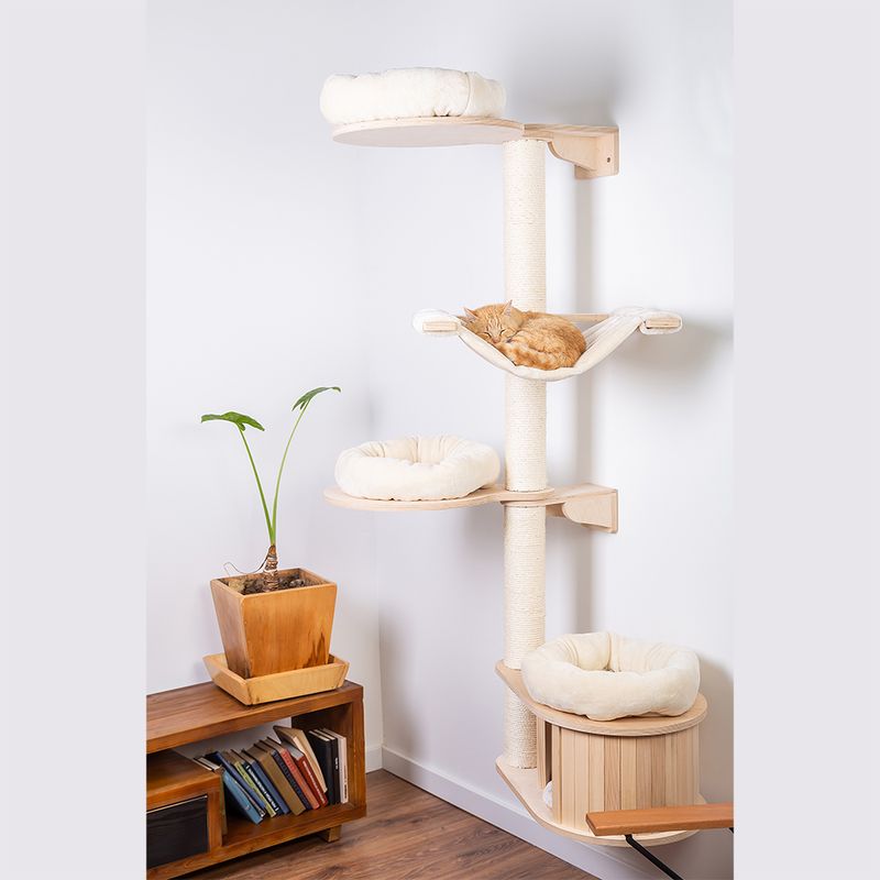 Cat tree made of wood with four levels, three padded resting areas and a hammock. A cat is sleeping on the hammock. Modern design, suitable for indoor use.
