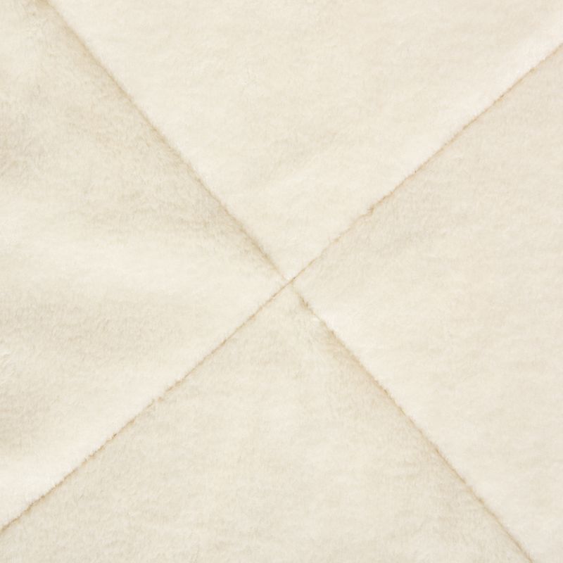 Close-up of a cream-coloured, soft fabric with diagonal seams. Material texture visible.