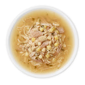 Close-up of a bowl with wet food, consisting of meat pieces and vegetables in broth.