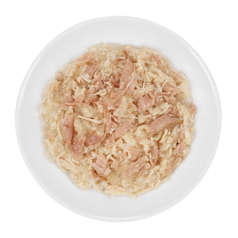 Close-up of shredded meat in jelly on a white plate, showing the consistency and ingredients of the pet food.