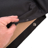 Close-up of a black, removable fabric cover with press stud fastening and underlying wooden board.