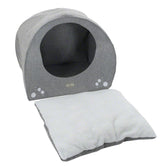 Grey, round pet bed with removable white cushion and decorative paw prints on the front.