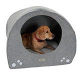Dog in grey dog cave with paw motif and padded lying surface. Visible logo: Trixie.