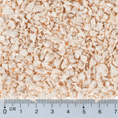 Close-up of light brown flakes with a ruler in centimetres for size reference. Flake size approximately 0 to 5 mm.