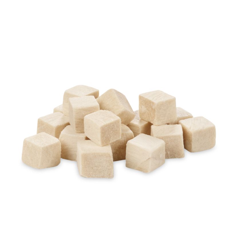 White, cube-shaped snacks made from freeze-dried meat, visibly arranged loosely.